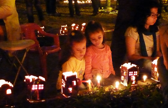 Young girls lighting candles in a park