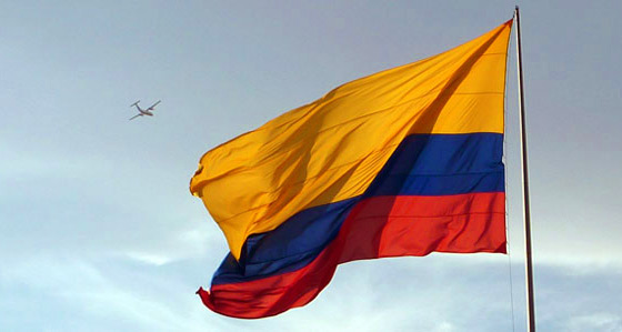 The Colombia flag with an airplane flying overhead