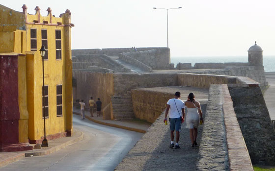 A couple take a stroll along the old city walls of Cartagena