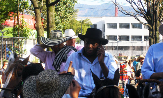 'El Tino' Asprilla takes a phone call during the Cabalgata in Medellin